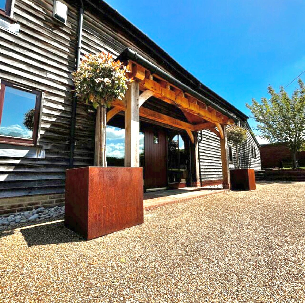 An image showcasing a pair of Corten steel planters. Here you can see the rugged durability along with the desirable aesthetics of the corten steel planters.