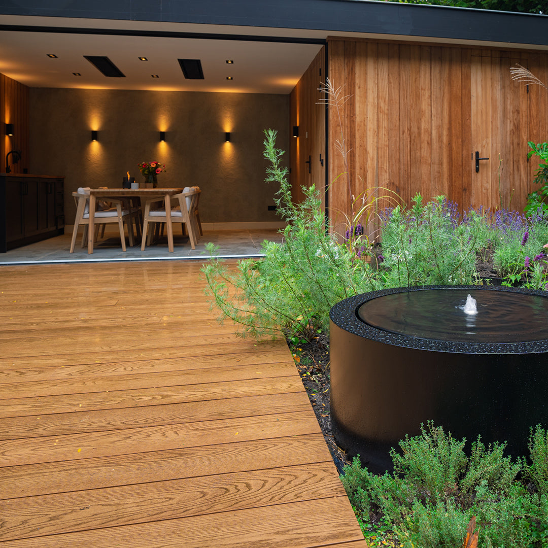 Aluminium circular water table in garden with decking