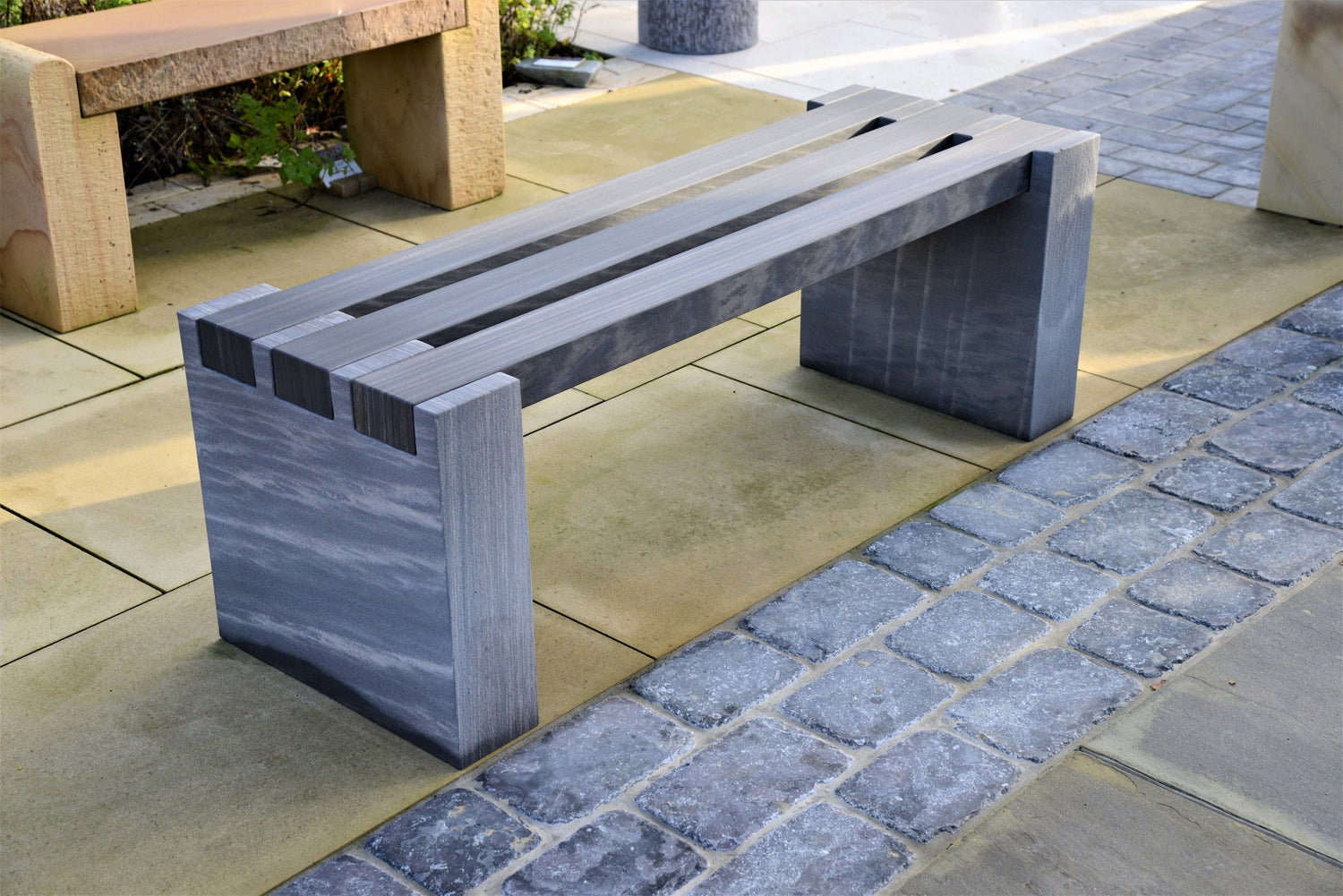 Image of a luxurious grey stone bench with a smooth design.