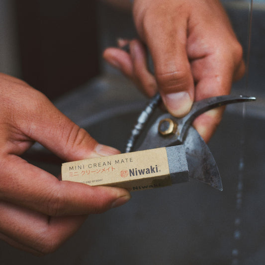 Person holding a mini cream mate and a knife with 'Niwaki' branding over a sink. (10247305461953)
